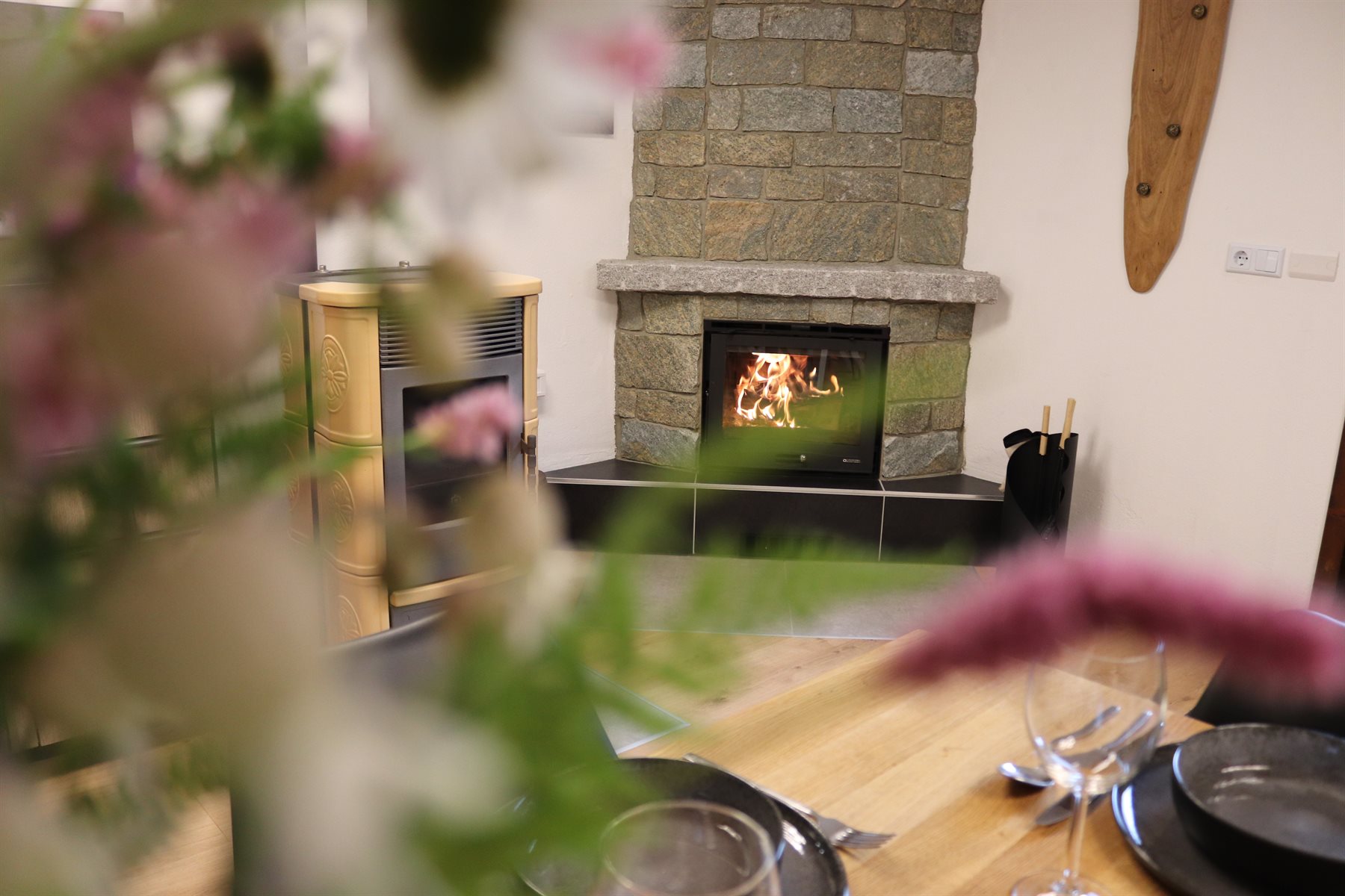 Blick durch Blumen auf Kamin und Pelletofen im Casa di Monti.